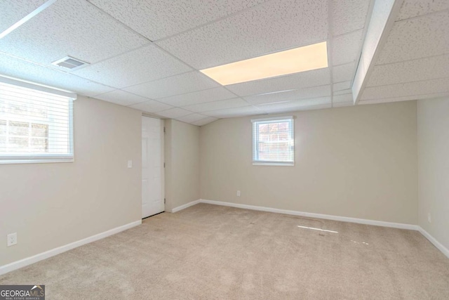 basement featuring carpet floors, a drop ceiling, and baseboards