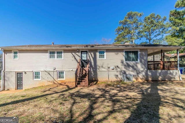 rear view of house featuring brick siding, a yard, stairway, and central air condition unit