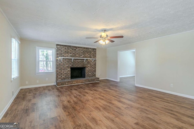 unfurnished living room featuring a ceiling fan, a fireplace, a textured ceiling, and wood finished floors