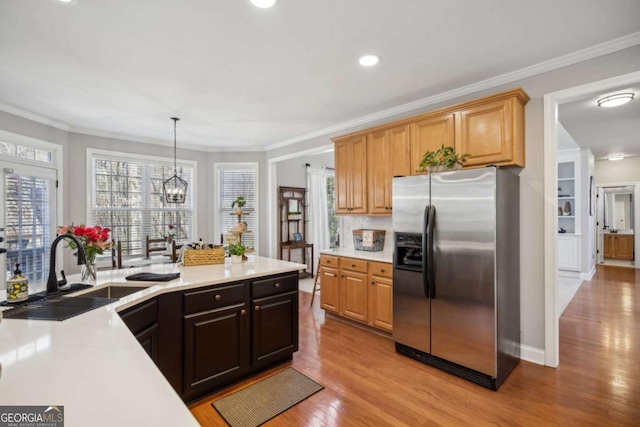 kitchen featuring light wood-style flooring, light countertops, ornamental molding, and stainless steel fridge with ice dispenser