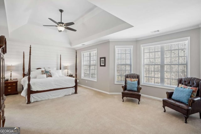 bedroom featuring a tray ceiling, multiple windows, light colored carpet, and baseboards