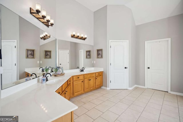 bathroom featuring a sink, baseboards, double vanity, and tile patterned floors