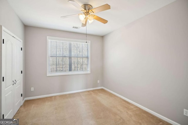 unfurnished bedroom with visible vents, baseboards, light carpet, a closet, and a ceiling fan