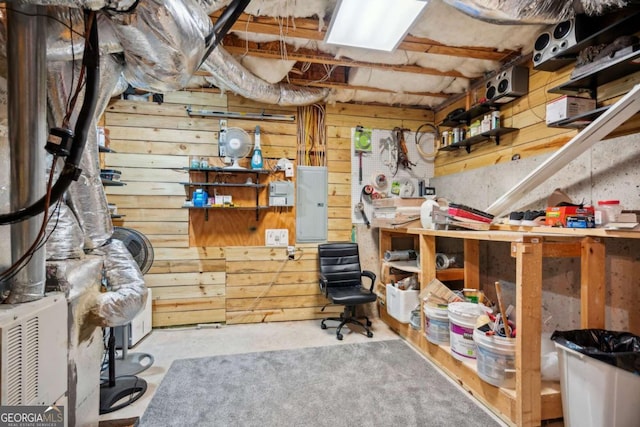 interior space featuring wooden walls, electric panel, and a workshop area