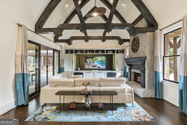 living area featuring a stone fireplace, plenty of natural light, and wood finished floors