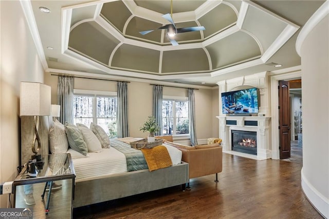 bedroom featuring a fireplace with flush hearth, wood finished floors, coffered ceiling, and ornamental molding