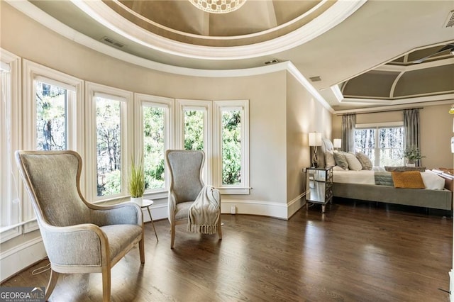 living area with crown molding, wood finished floors, visible vents, and a tray ceiling