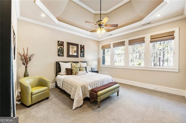 carpeted bedroom featuring visible vents, multiple windows, a raised ceiling, and ornamental molding