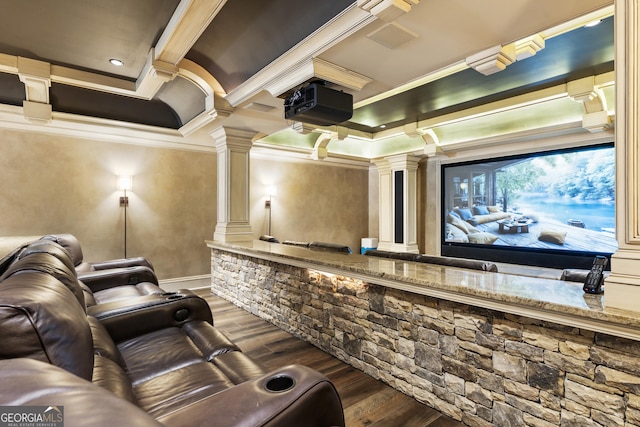 cinema room with coffered ceiling, crown molding, ornate columns, and wood finished floors