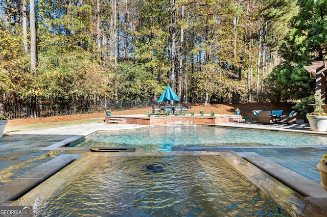 view of swimming pool with a patio area and fence