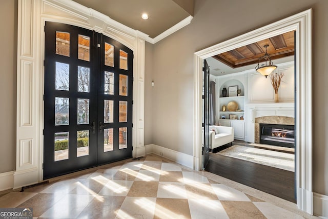 entryway featuring crown molding, baseboards, a premium fireplace, recessed lighting, and french doors