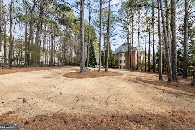 view of yard with driveway and fence