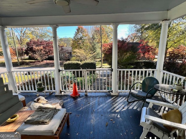 wooden deck featuring covered porch and ceiling fan