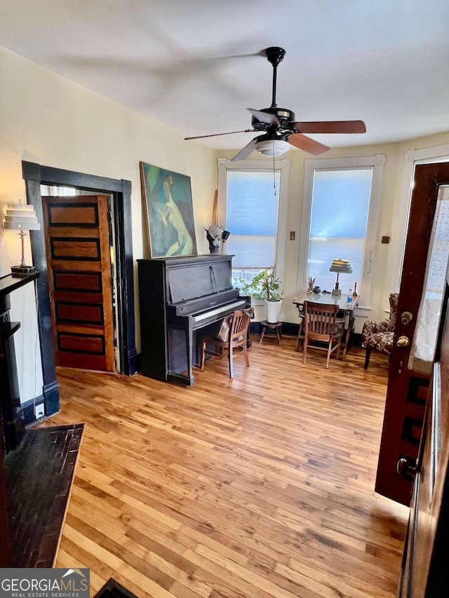 living area with light wood-style flooring and ceiling fan