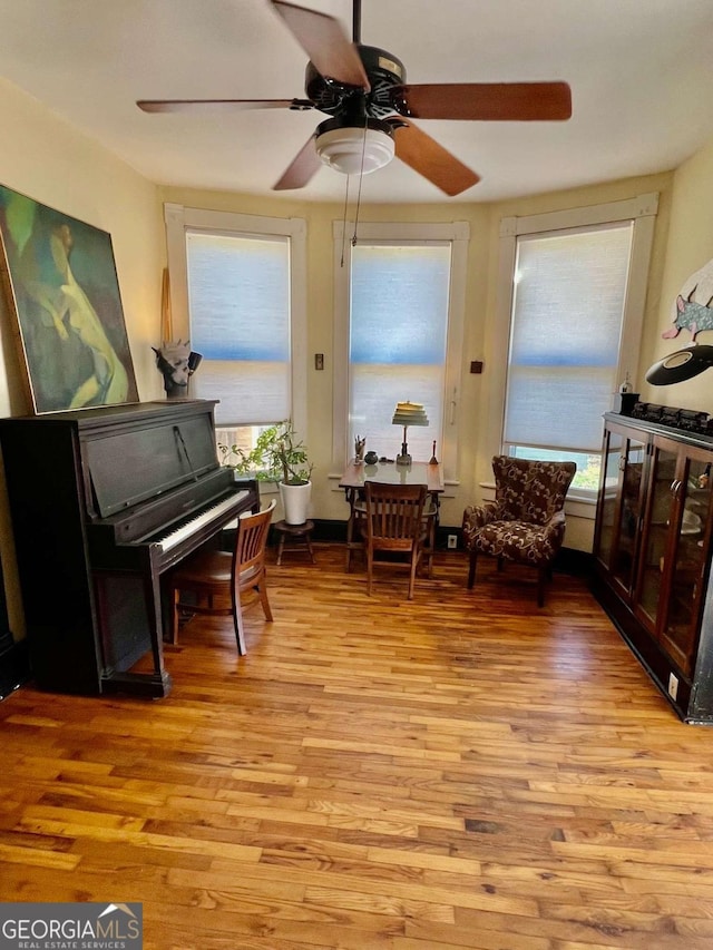 living area featuring light wood-style floors and a ceiling fan