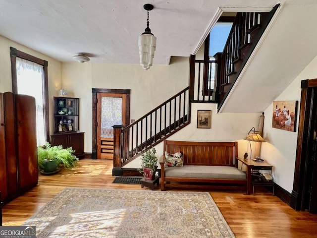 foyer with baseboards, stairway, and wood finished floors