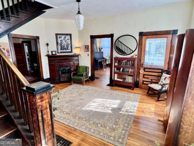 interior space with stairway, a fireplace, wood finished floors, and visible vents