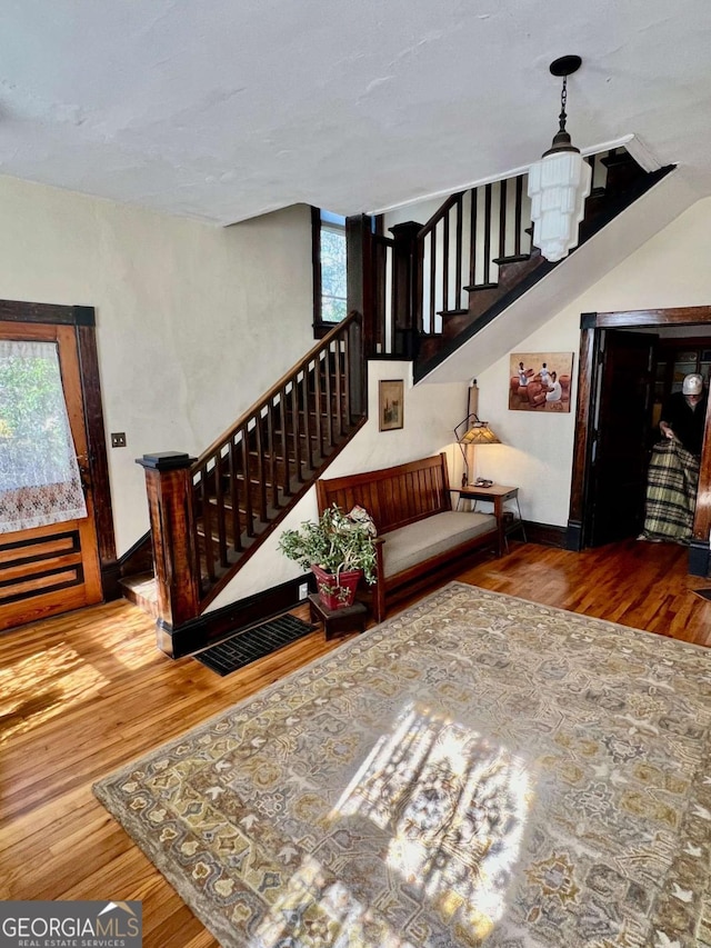 living area featuring stairway, wood finished floors, and baseboards