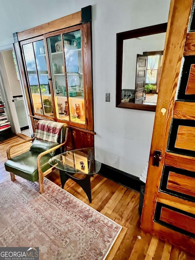 sitting room with plenty of natural light, baseboards, and wood finished floors