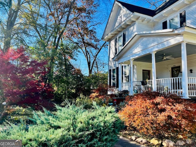 view of property exterior featuring covered porch and a ceiling fan