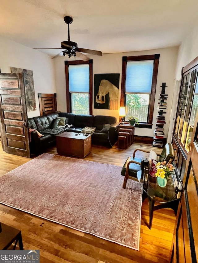 living area featuring ceiling fan, plenty of natural light, and wood finished floors