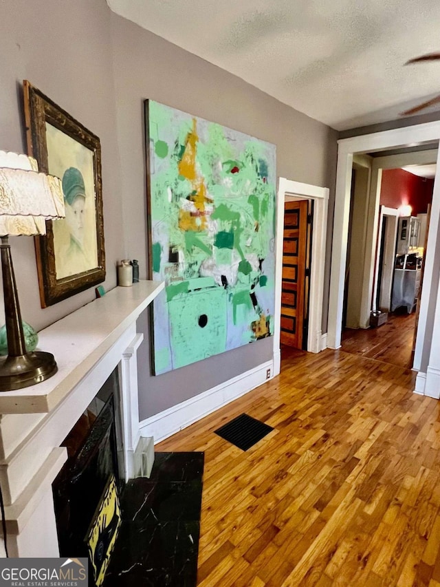 interior space featuring a textured ceiling, baseboards, and wood finished floors