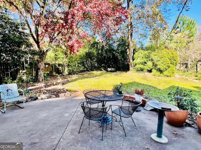 view of patio with outdoor dining area and fence