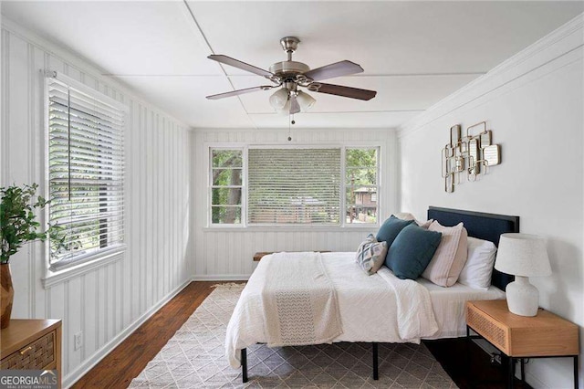 bedroom with ornamental molding, dark wood-type flooring, and a ceiling fan