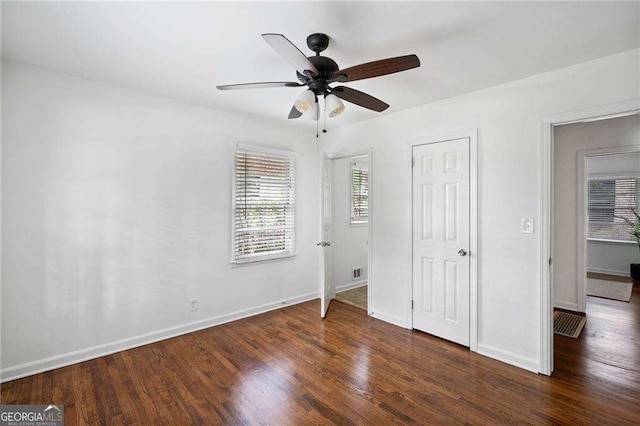 unfurnished bedroom with ceiling fan, wood finished floors, visible vents, and baseboards