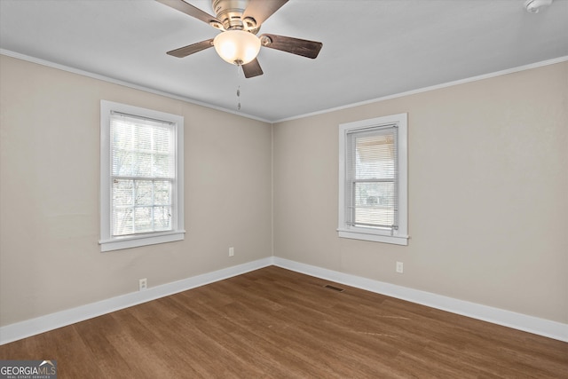 unfurnished room featuring a wealth of natural light, visible vents, baseboards, and wood finished floors