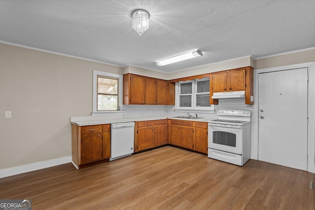 kitchen featuring light countertops, white appliances, light wood-style flooring, and under cabinet range hood