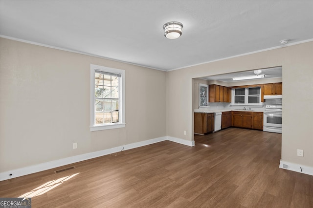 interior space featuring crown molding, baseboards, dark wood finished floors, and a sink