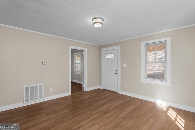 foyer with a wealth of natural light, visible vents, baseboards, and wood finished floors