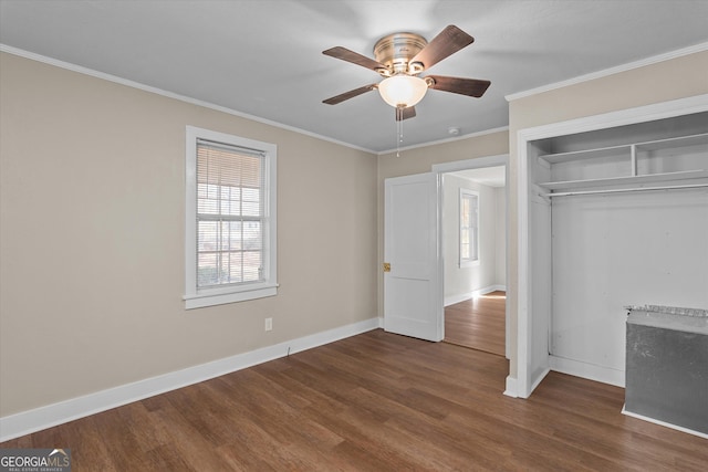 unfurnished bedroom with dark wood-style floors, a closet, crown molding, and baseboards