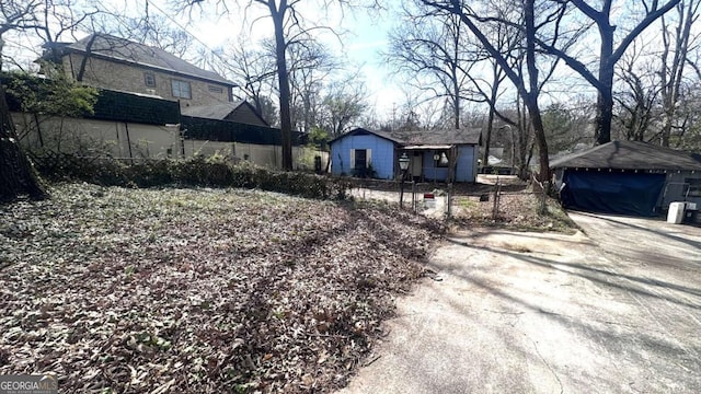 view of yard featuring an outdoor structure and fence