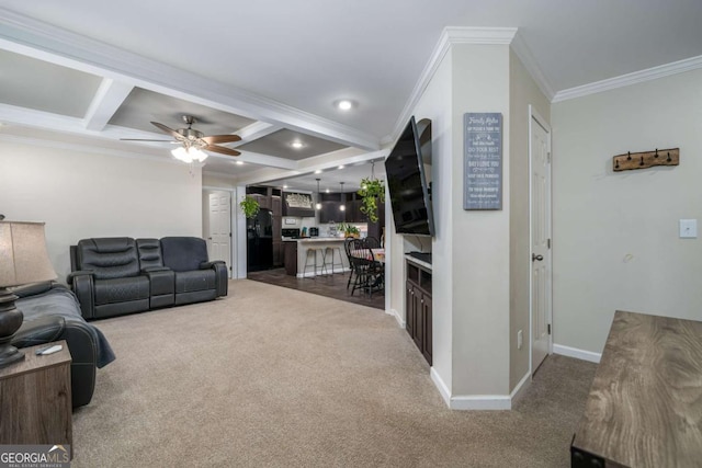 carpeted living area with baseboards, coffered ceiling, a ceiling fan, ornamental molding, and beamed ceiling