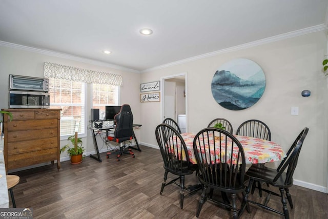 dining space with baseboards, wood finished floors, and crown molding