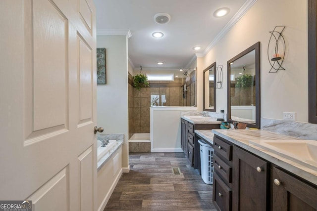 bathroom featuring a garden tub, walk in shower, vanity, and crown molding