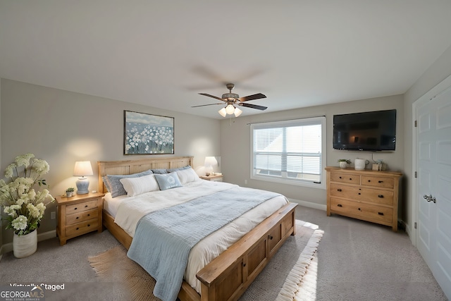 bedroom featuring light colored carpet, baseboards, and ceiling fan