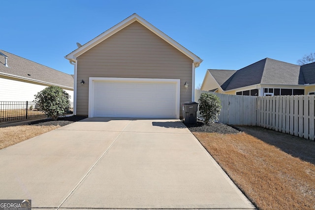 garage with driveway and fence