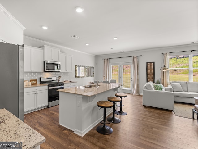 kitchen featuring stainless steel appliances, dark wood finished floors, visible vents, and a sink