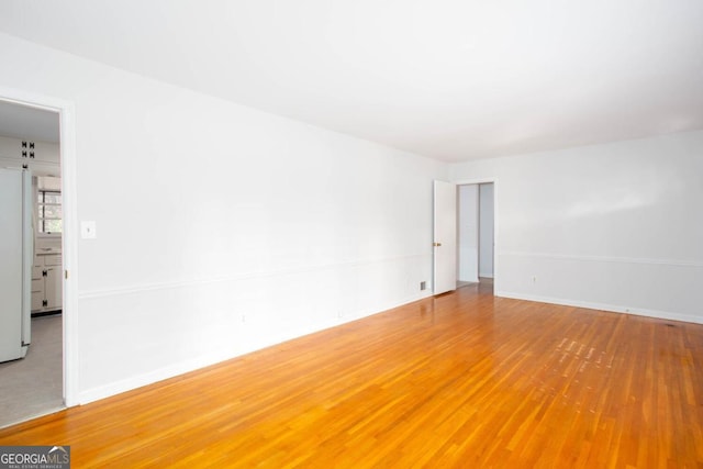 unfurnished room featuring wood finished floors and baseboards