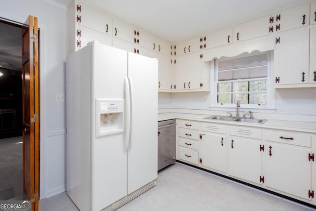 kitchen featuring light countertops, white refrigerator with ice dispenser, white cabinetry, dishwasher, and a sink