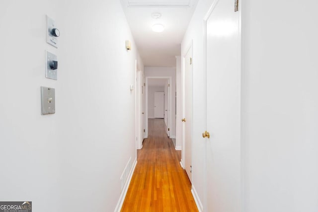 hallway with light wood-style flooring and baseboards