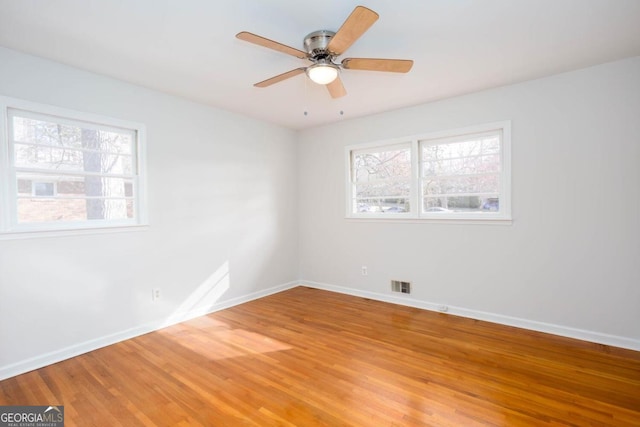 unfurnished room with light wood-style flooring, baseboards, a ceiling fan, and visible vents