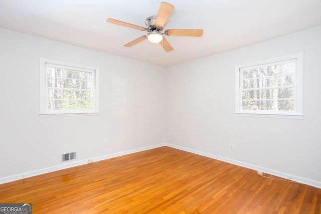 empty room featuring visible vents, baseboards, ceiling fan, and light wood-style floors