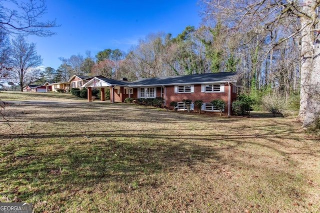 view of front of home featuring a carport, a front yard, and brick siding