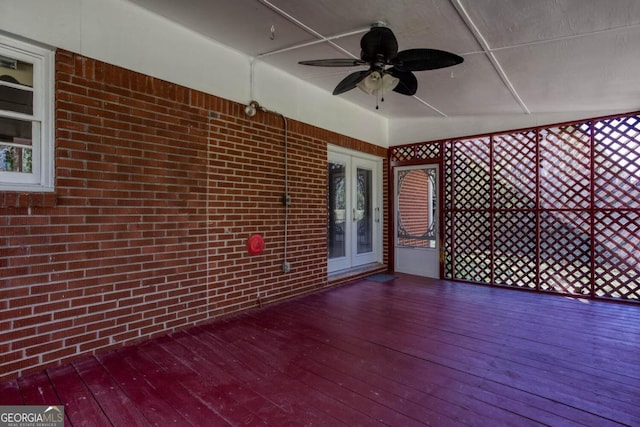 unfurnished sunroom with a ceiling fan