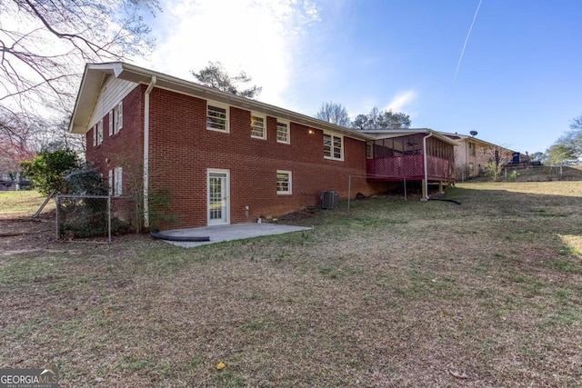 rear view of house featuring central AC, a lawn, a patio area, fence, and brick siding