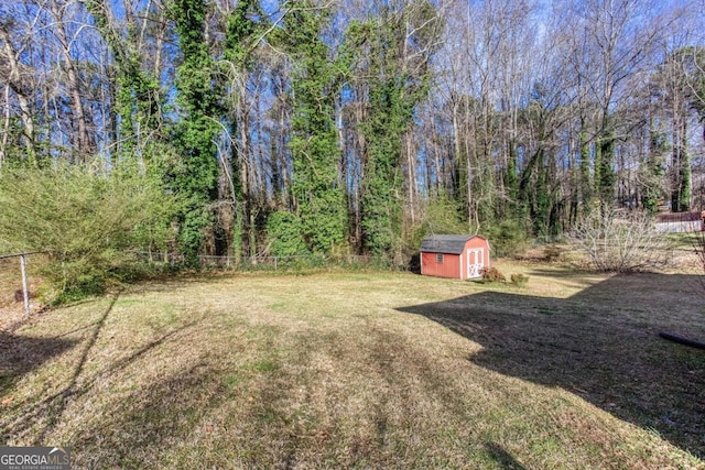 view of yard with an outbuilding, fence, and a shed